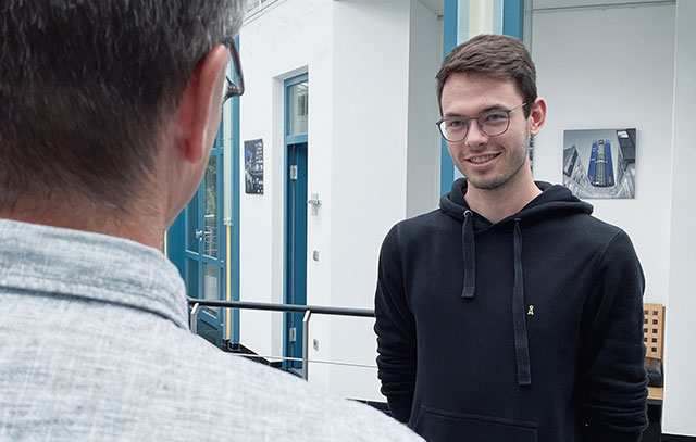 A young man talks to an older man