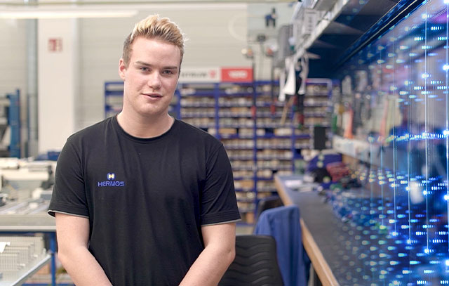 An apprentice stands at a workbench