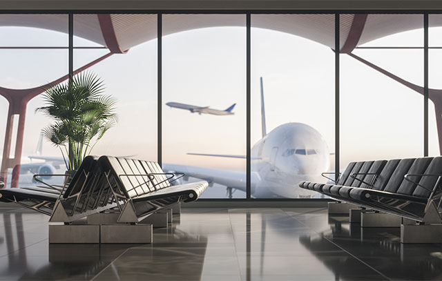 Wartehalle eines Flughafens mit Glasfront, davor ein Flugzeug