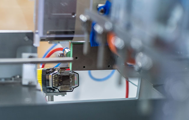 A camera hangs on an assembly line