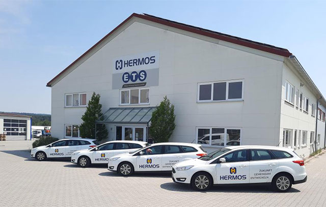 Exterior view of building in Schnaittenbach - in front of it 4 white cars with HERMOS logo